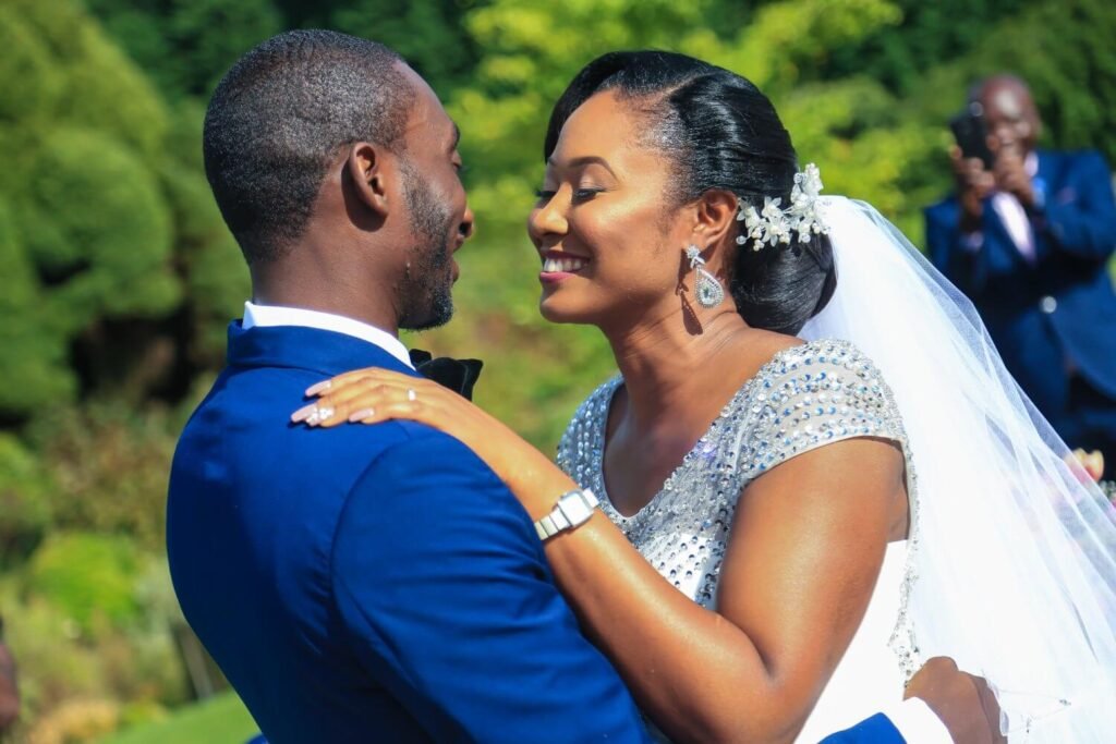 A young and beautiful bride Chidinma and her husband Tolulope is standing looking looking into each others' eyes as they are about to kiss at their wedding ceremony